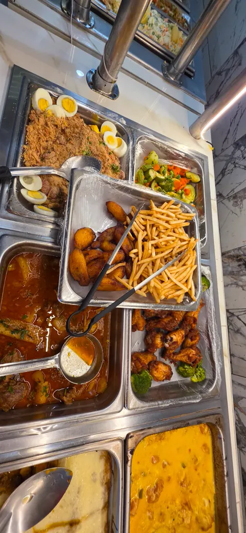Buffet with farofa and boiled eggs, fried plantains, fries, chicken wings and stews