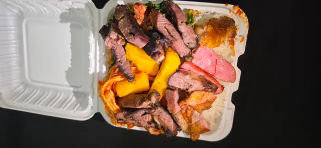 Takeout plate with churrasco, cassava, rice and sides