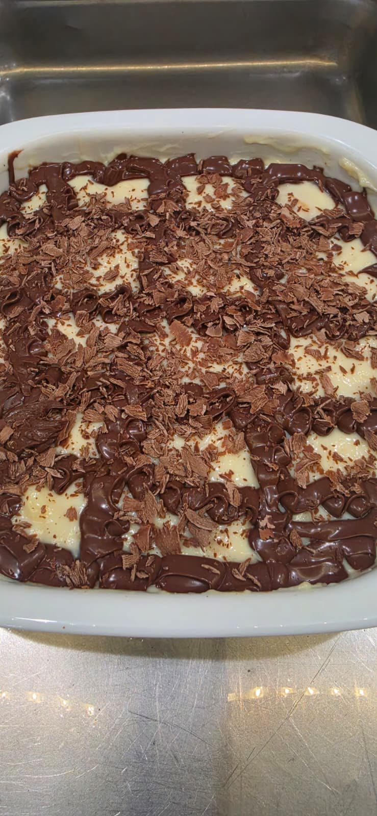 Dish of cream dessert covered in chocolate and chocolate shavings